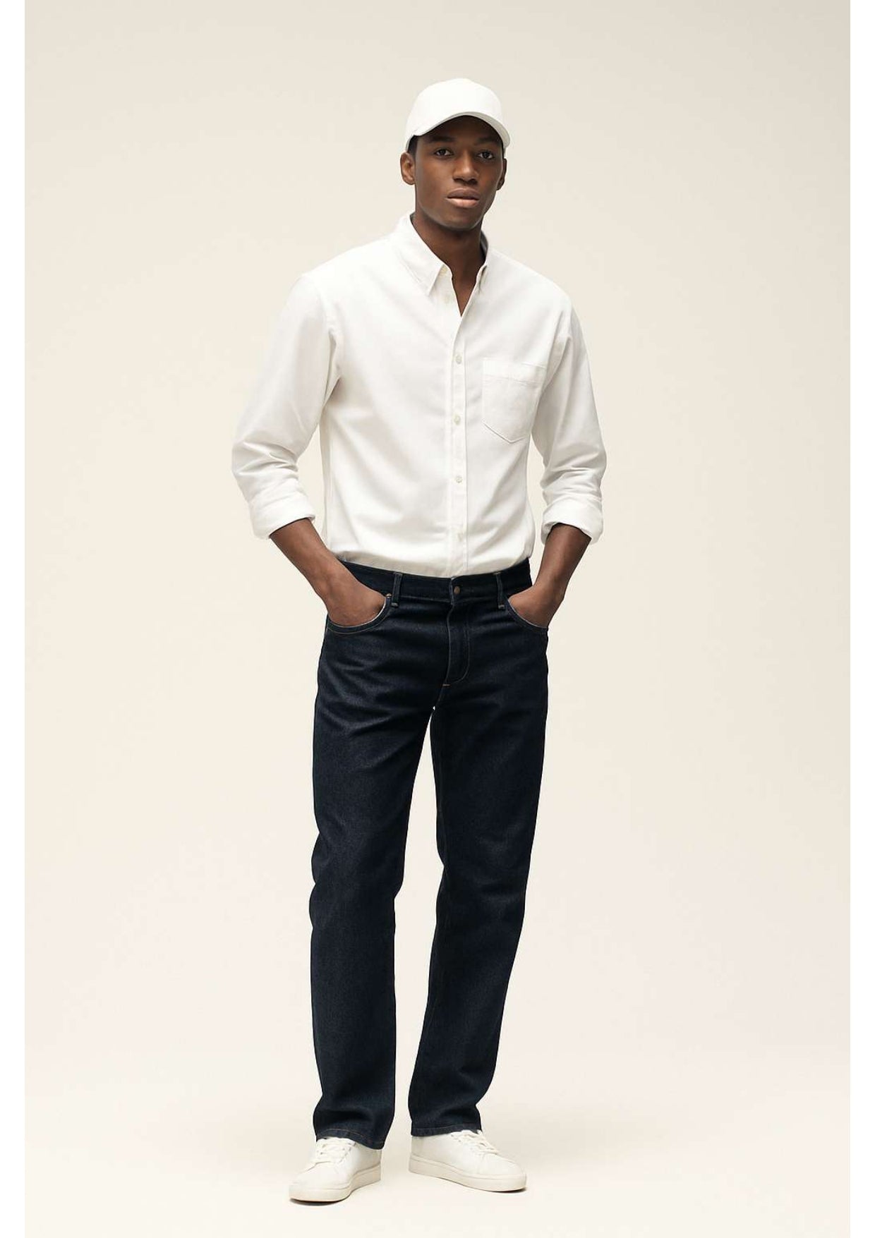 Men wearing white shirt with blue streight leg jeans and a cap 