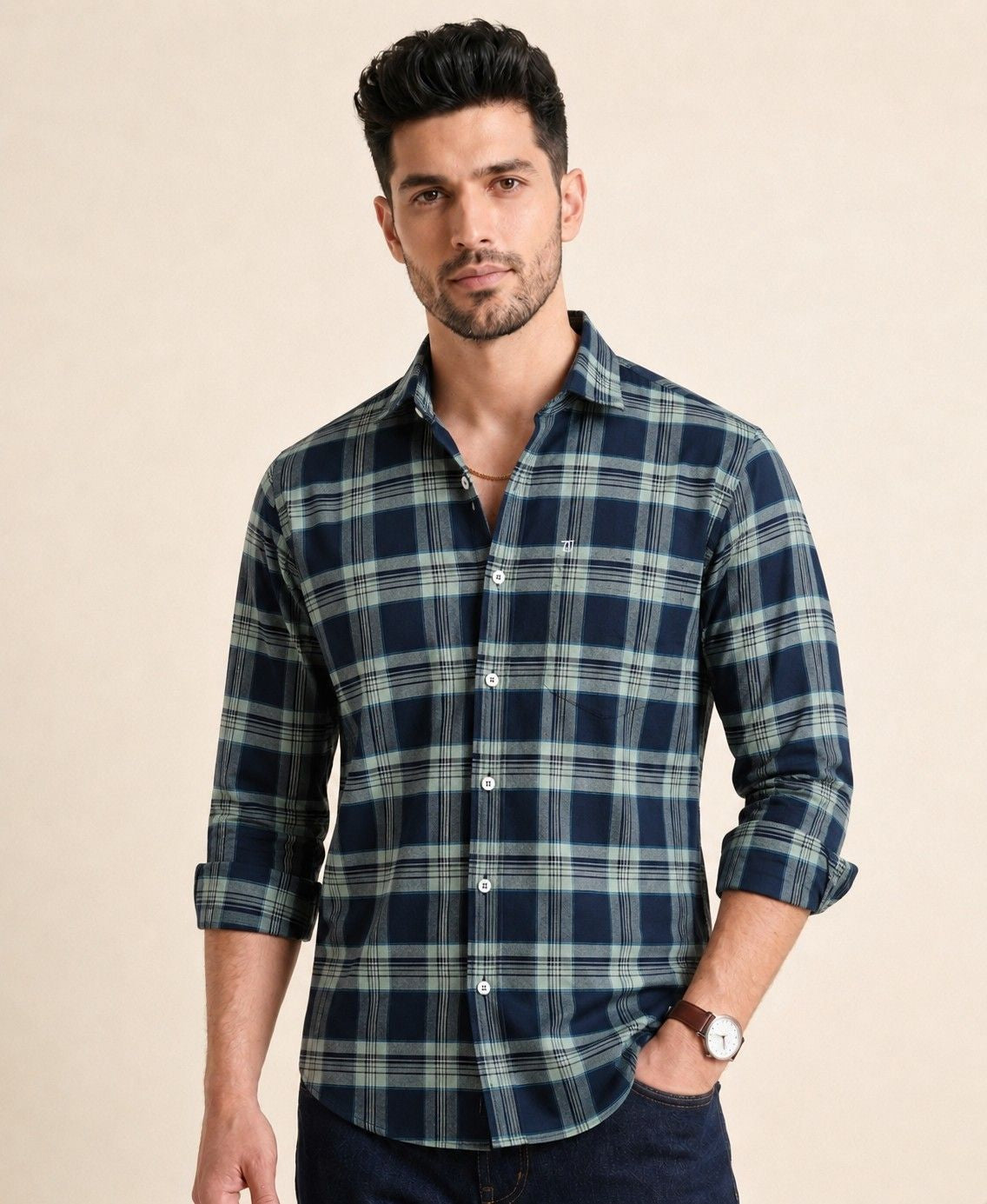 Man wearing a blue and green plaid shirt against a beige background