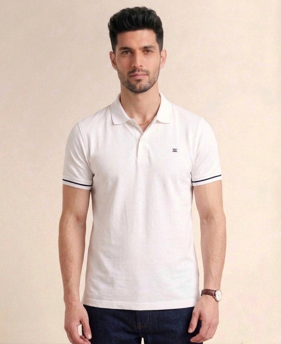 Man wearing a white polo shirt with black trim on a beige background