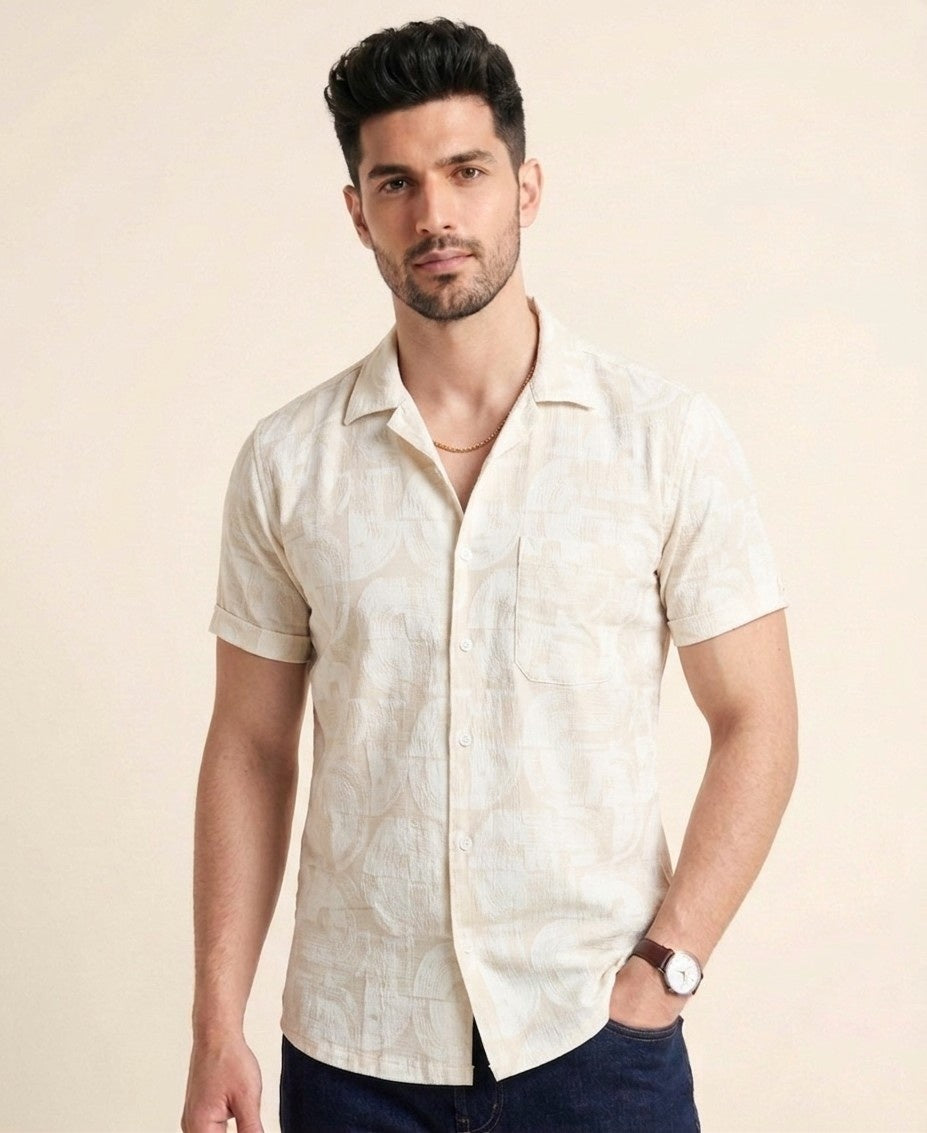 Man wearing a beige patterned shirt against a beige background