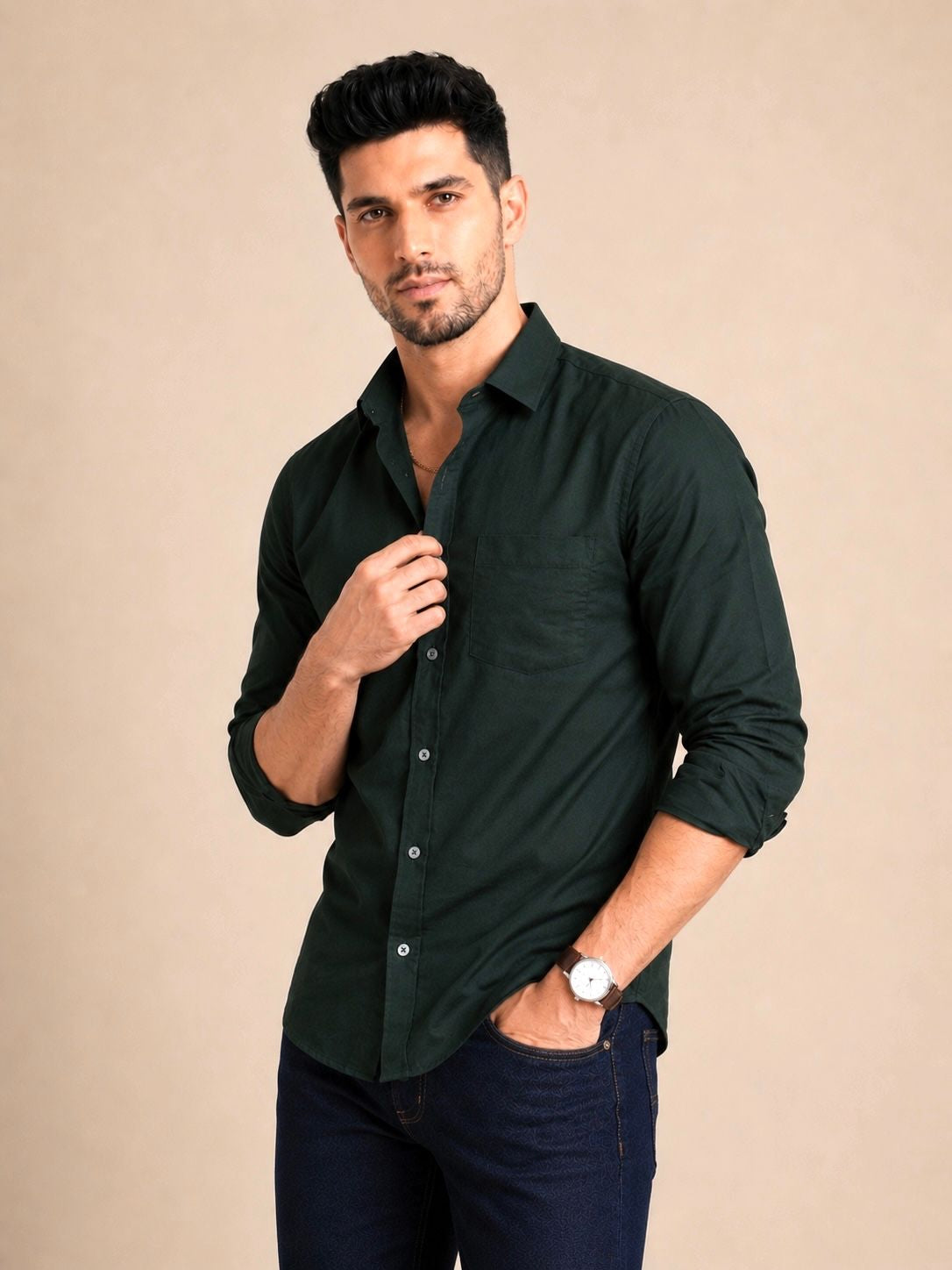 Man wearing a dark green shirt against a beige background