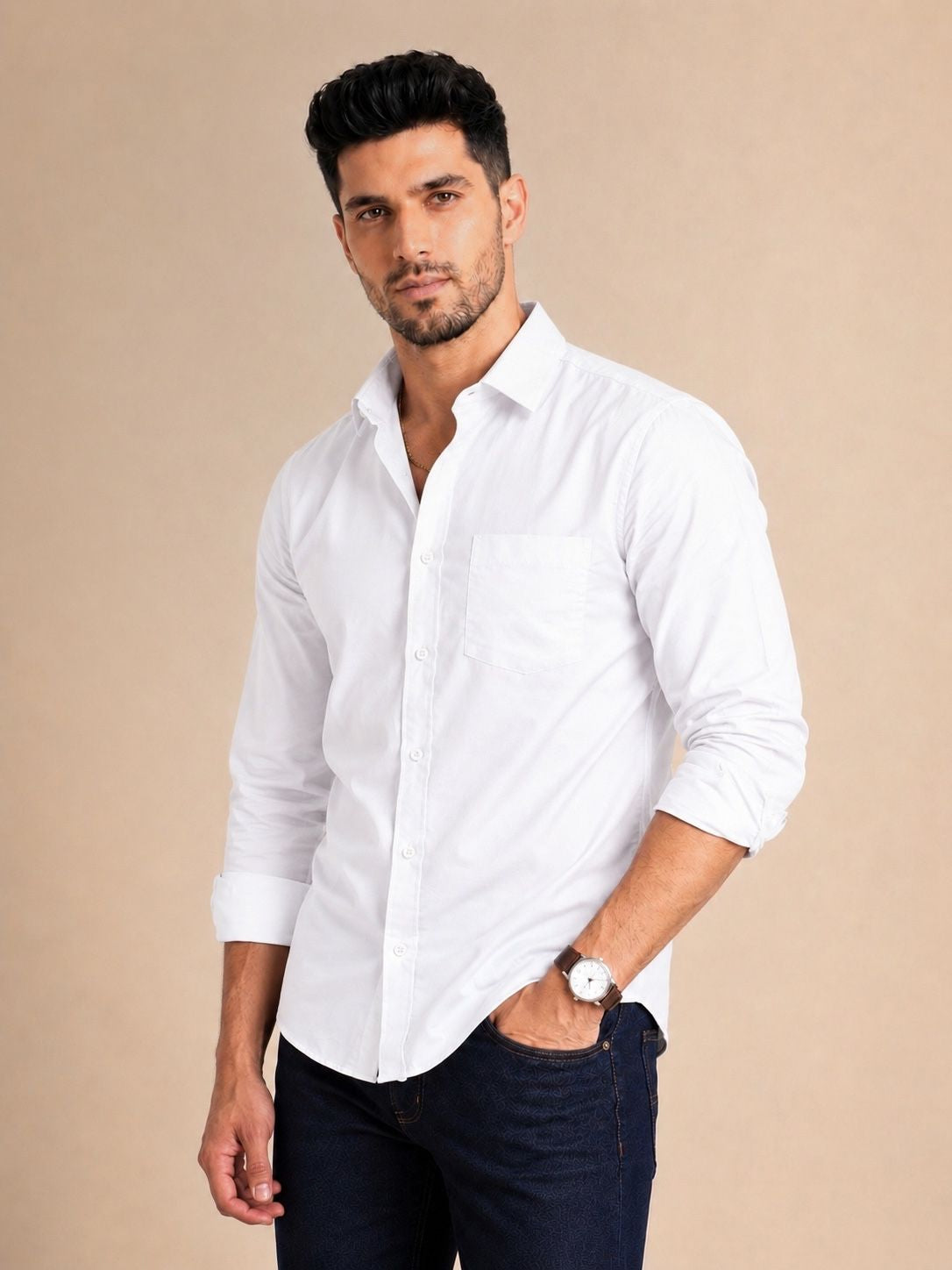 Man wearing a white shirt and dark pants against a beige background